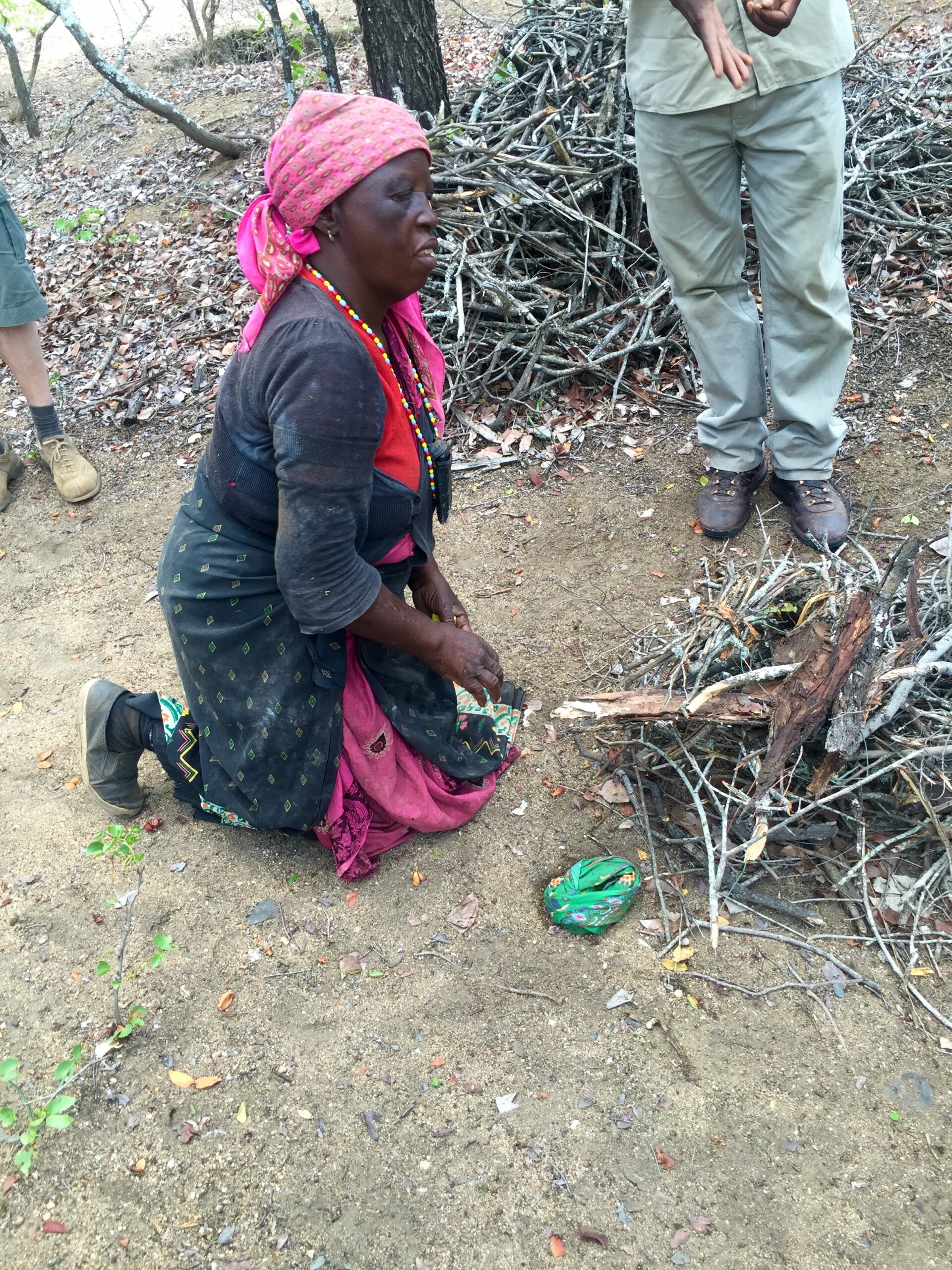 A Tsonga salt-maker kneeling to make an offering to the ancestors at the leadwood tree before the salt harvest at Baleni
